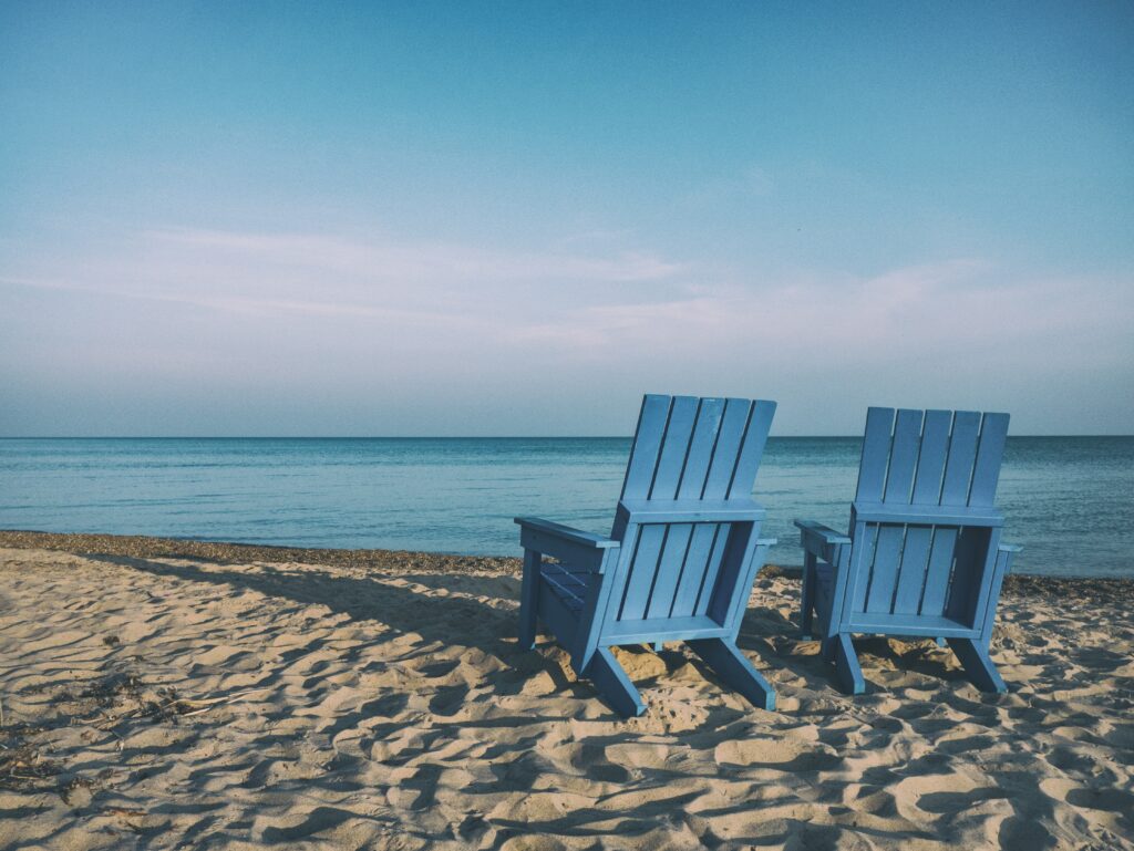 two empty beach chairs sitting on the beach
